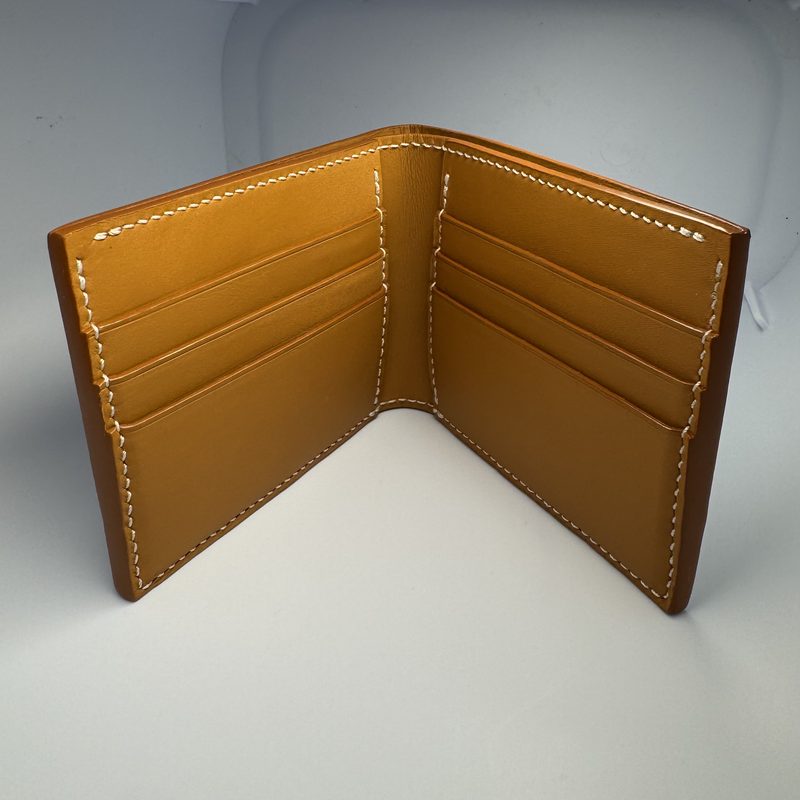The second wallet open flat, showing six tan card slots stitched in white thread